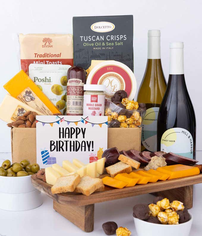 An abundant gift box filled with two bottles of California wine - red & white, assorted crackers, three cheeses, summer sausage, snacks, and birthday card to make an amazing birthday spread.