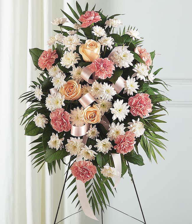 Pastel roses and carnation funeral flower stand