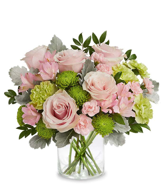 Image of a Mother's Day arrangement featuring Light Pink Roses, Light Pink Alstroemeria, Green Carnations, Miniature Light Pink Carnations, and floral greenery, presented in a keepsake iridescent mosaic vase.