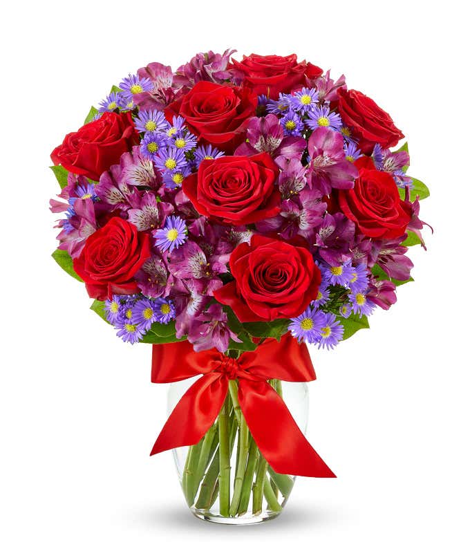 Red roses arranged with purple alstroemeria and monte casino.