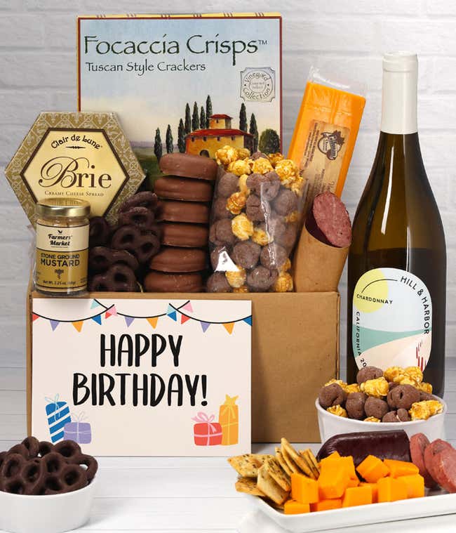 A gift set featuring a bottle of California Chardonnay, focaccia crisps, two cheeses, mustard, summer sausage, caramel popcorn, chocolate pretzels, six chocolate-covered Oreos and a Birthday card to complete the gourmet experience.