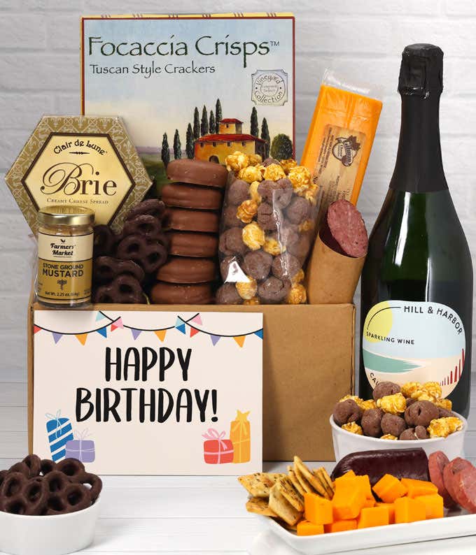 A gift set featuring a bottle of California Sparkling Wine, focaccia crisps, two cheeses, mustard, summer sausage, caramel popcorn, chocolate pretzels, six chocolate-covered Oreos and a Birthday card to complete the gourmet experience.