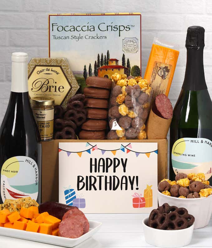 A gift set featuring 2 bottles of Hill & Harbor wine - red and sparkling, focaccia crisps, two cheeses, mustard, summer sausage, caramel popcorn, chocolate pretzels, six chocolate-covered Oreos and a Birthday card to complete the gourmet experience.