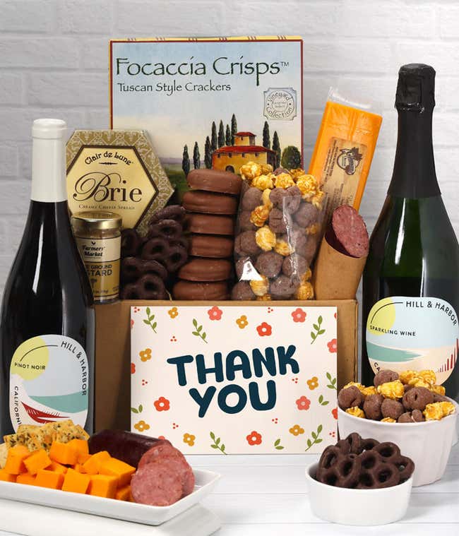 A gift set featuring 2 bottles of Hill &amp; Harbor wine - red and sparkling, focaccia crisps, two cheeses, mustard, summer sausage, caramel popcorn, chocolate pretzels, six chocolate-covered Oreos and a Thank You card to complete the gourmet experience.