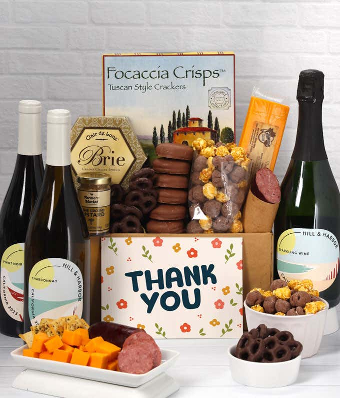 A gift set with a trio of California wines - red, white, and sparkling, focaccia crisps, two cheeses, mustard, summer sausage, caramel popcorn, chocolate pretzels, six chocolate-covered Oreos and a Thank You card to complete the gourmet experience.