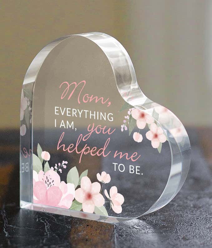 An acrylic heart with pink flowers, and a quote that reads: Mom, everything I am, you helped me to be